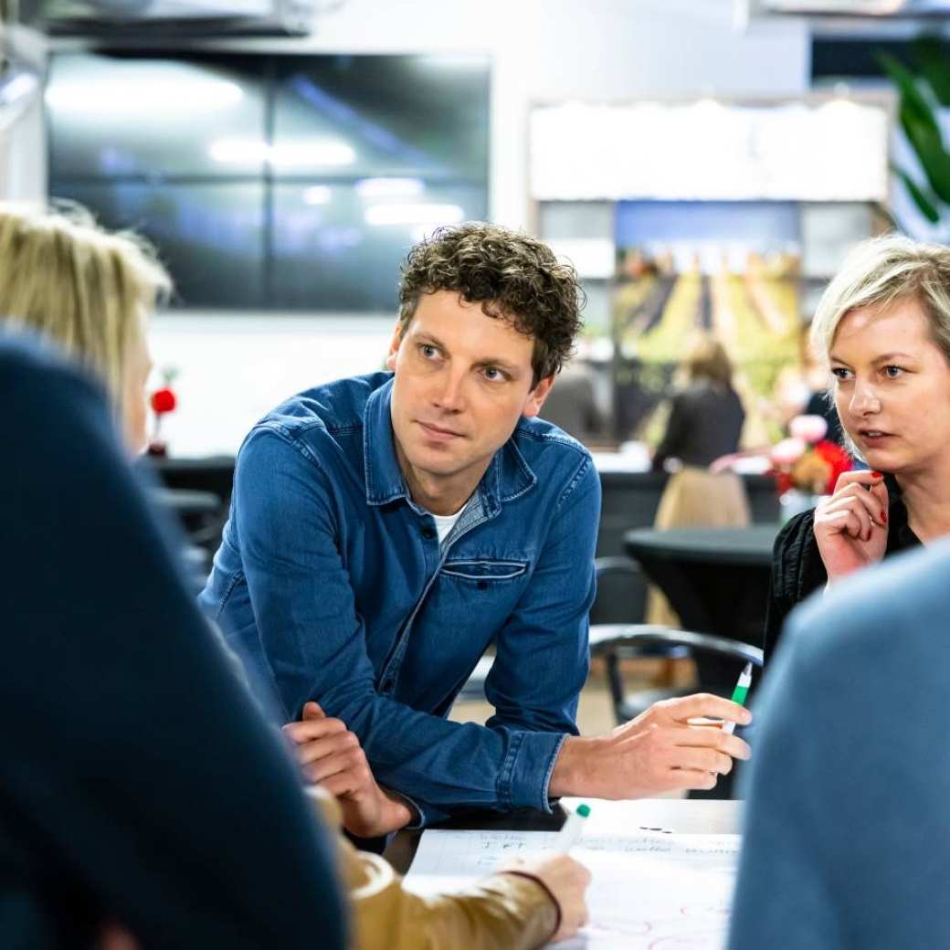 Man leunt op tafel en luistert 