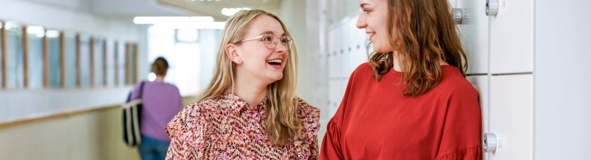 Twee studenten lachen naar elkaar