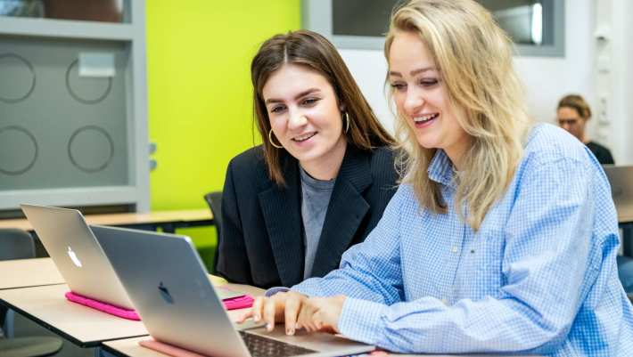 Ondernemerschap & Retail Management 2 studenten achter laptop