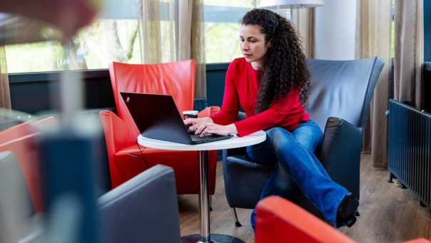 Deeltijdstudent onderzoekt studiekosten achter de laptop.