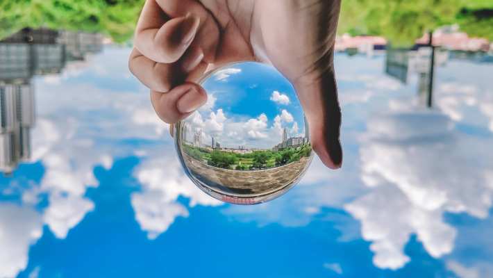 Foto van een glazen bol met natuur en stad