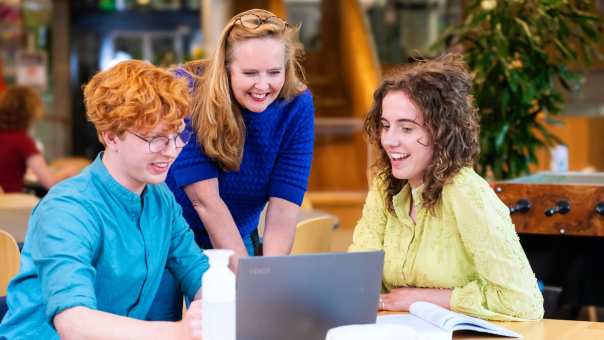 Docent en twee studenten lachen