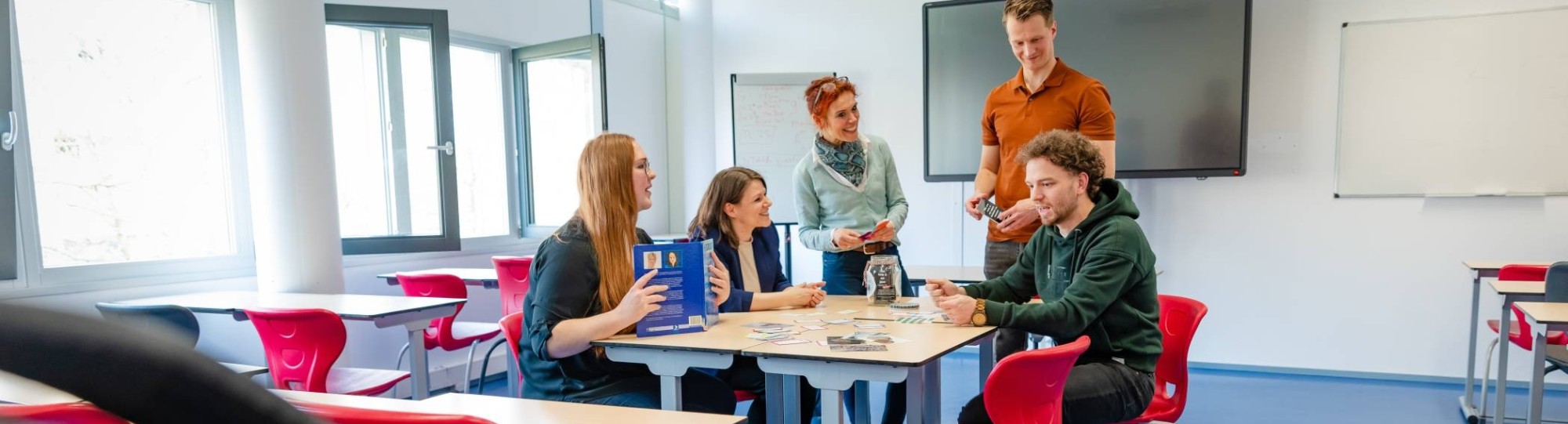 Een groepje studenten van de master Human Capital Innovation werken samen in een lokaal aan een opdracht