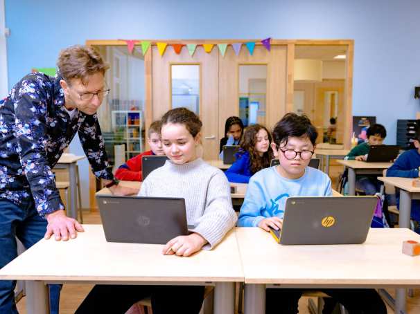 Groep 5,6,7 op de school Da Vince. 
De kinderen werken in de klas achter de laptop. 