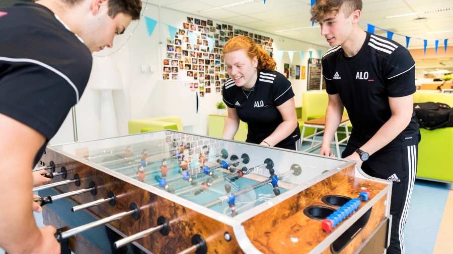 Pabo-ALO studenten spelen een potje tafelvoetbaltafel in de pauze.