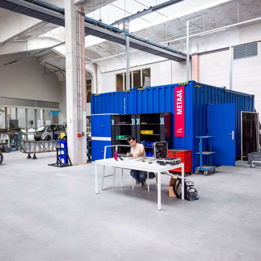 Overzicht van de container op het Mobility Innovation lab bij HAN Connectr op het IPKW. Een student werkt met metaal.