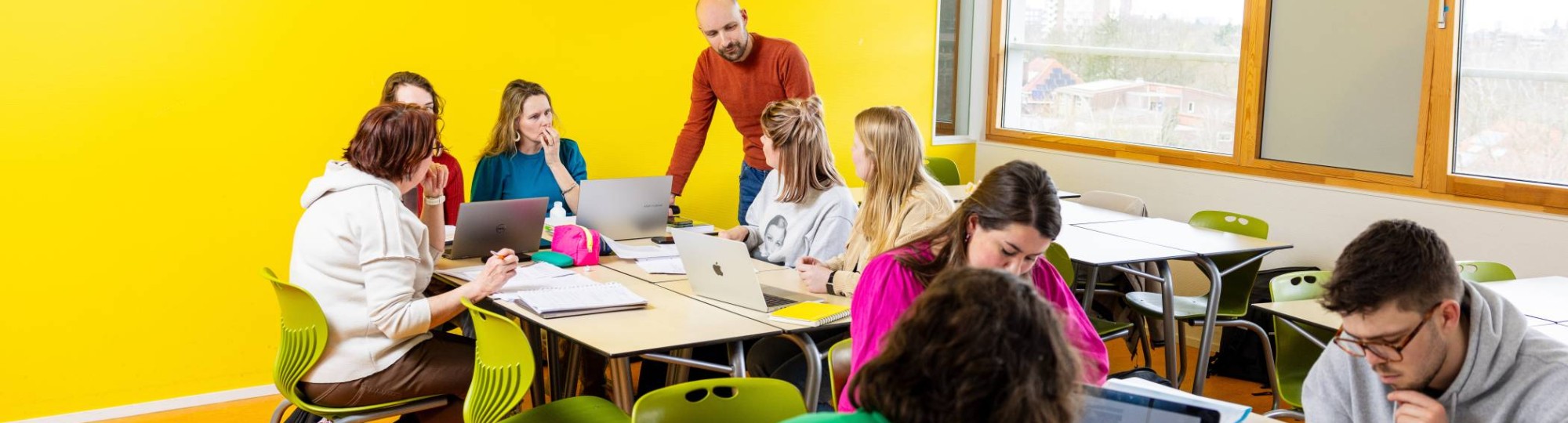 Twee studenten die serieus aan het werk zijn achter een laptop in de mediatheek.