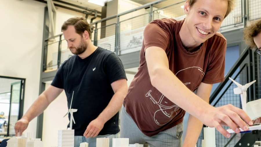 Drie studenten van de masteropleiding Engineering Systems: Sustainable Energy bij de Smart Grid-demotafel.