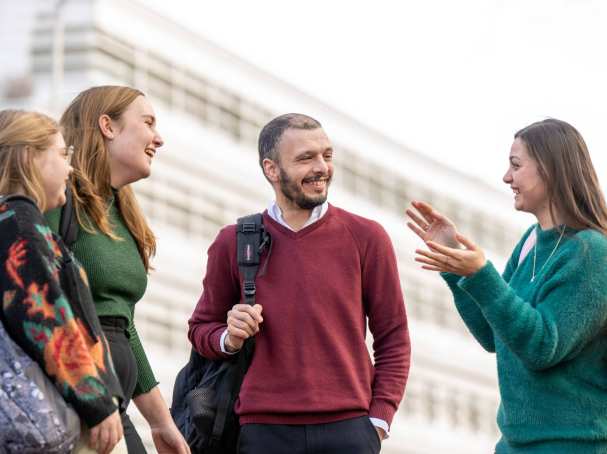 4 studenten praten buiten met elkaar.