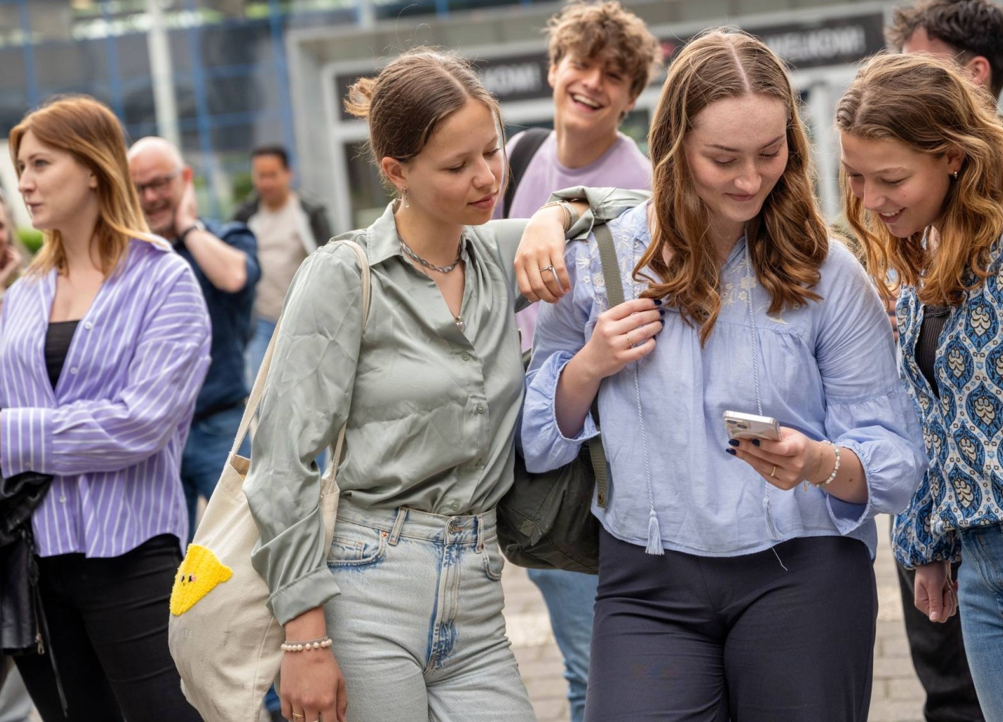 studenten van de HAN kijken buiten op de campus op hun telefoon