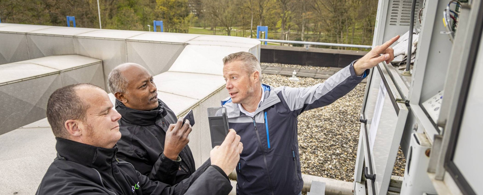 Drie Vastgoedinspecteurs overleggen tijdens een inspectie.