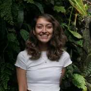 Portret Cheryl van den Bovenkamp wit shirt planten achtergrond