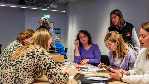 Groepjes werken samen tijdens de sessie: 'Open Leren: Escape Experience' tijdens de Onderwijsdagen 2026. Marijn Post helpt een deelnemende groep.
