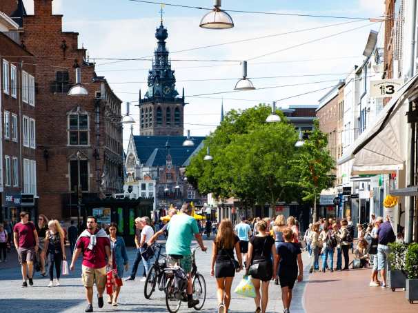 mensen in winkelstraat met kerk op achtergrond