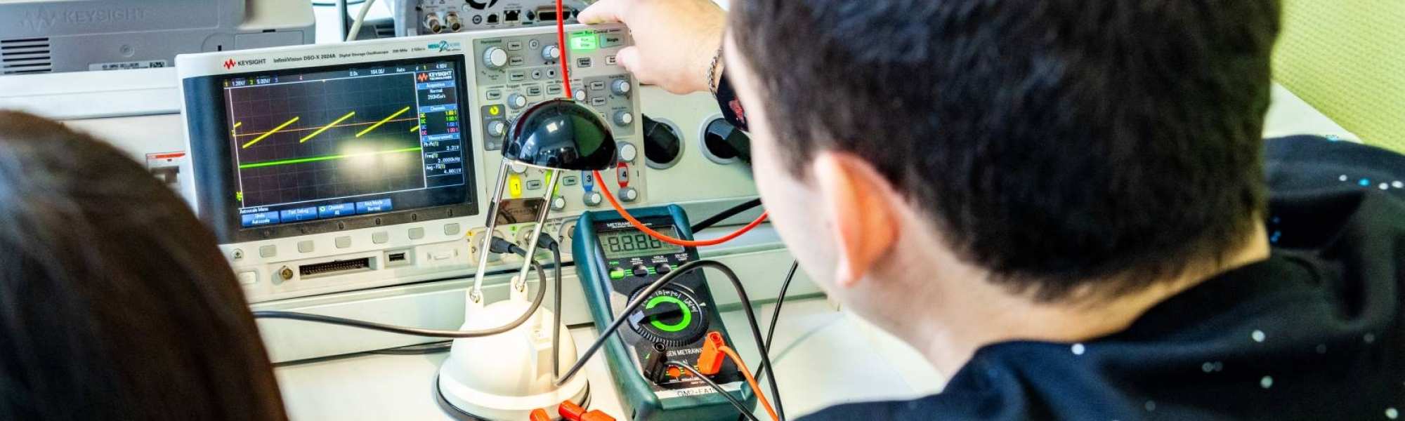 Twee studenten elektrotechniek doen een experiment met een zonnepaneel.