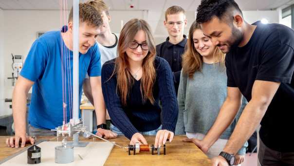 Studenten Werktuigbouwkunde experimenteren met een mechanische batterij, een katrol en een spoel