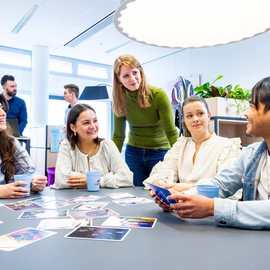 veel studenten in een hoorcollege zaal achter een laptop scherm