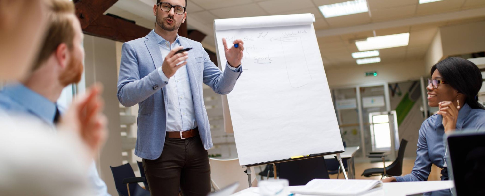 Praktijk docent van de post-hbo opleiding Sales Management tijdens college in gesprek met deelnemers op de HAN campus Arnhem.