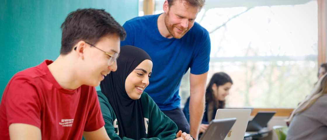 HAN Academie Educatie, Pabo, Pabo-ALO, ALPO, voltijd en deeltijd, docent kijkt met studenten mee naar de laptop in de les, 2024