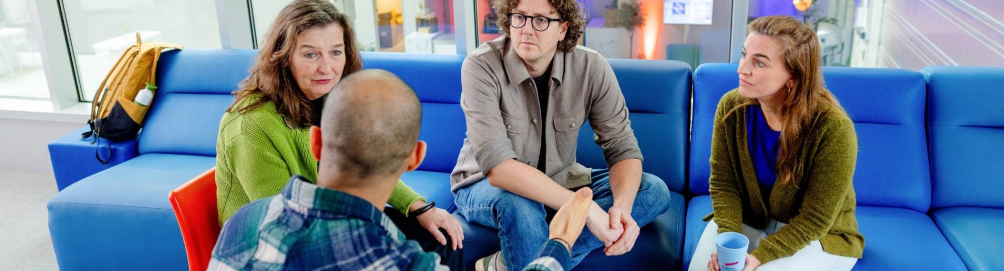 Docent kijkt via de laptop mee naar het werk van haar drie studenten.