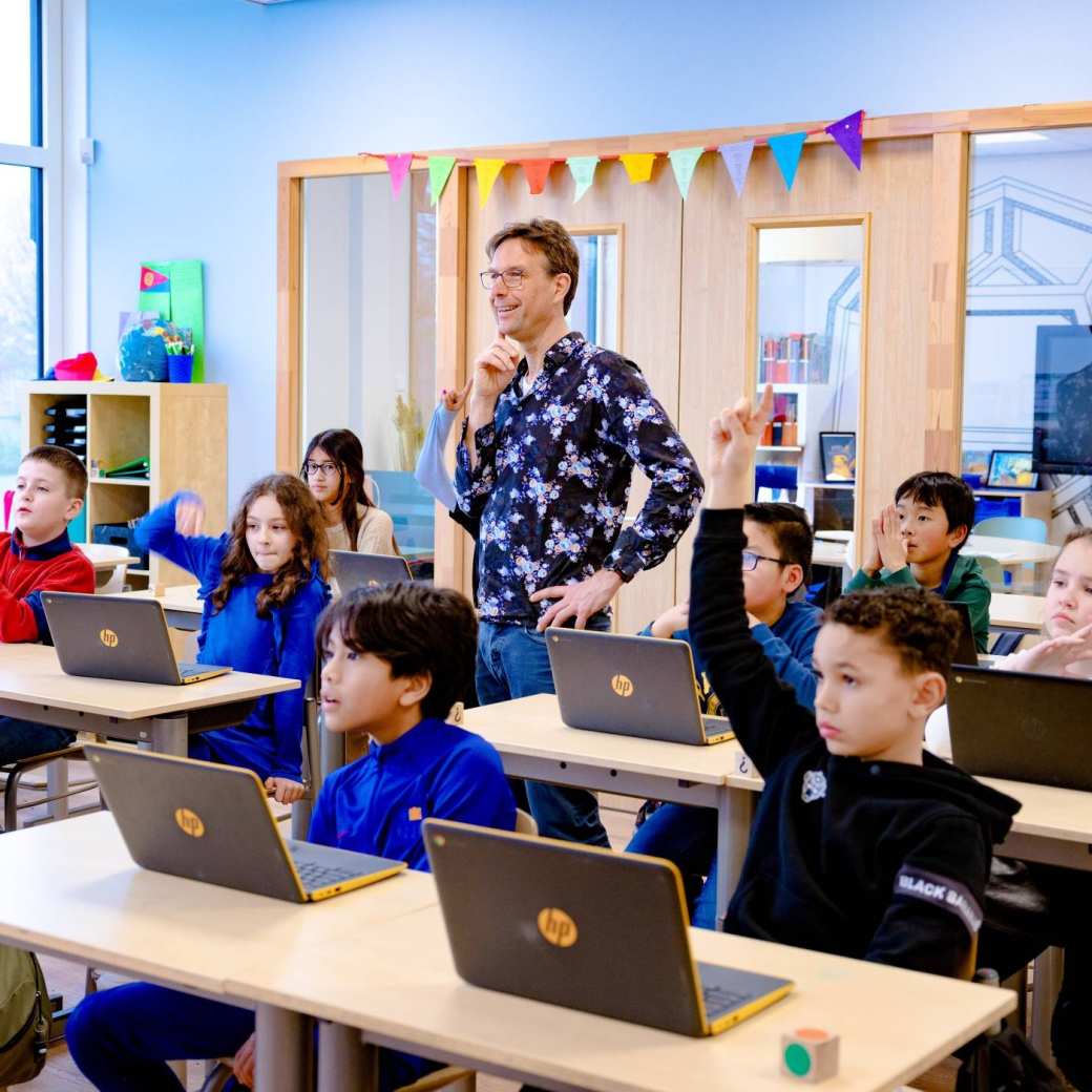 Leraar geeft muziekles aan kinderen op de basisschool.