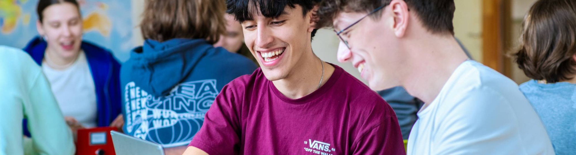 Drie studenten Leraar Frans krijgen uitleg van hun docent die tussen hen in staat.