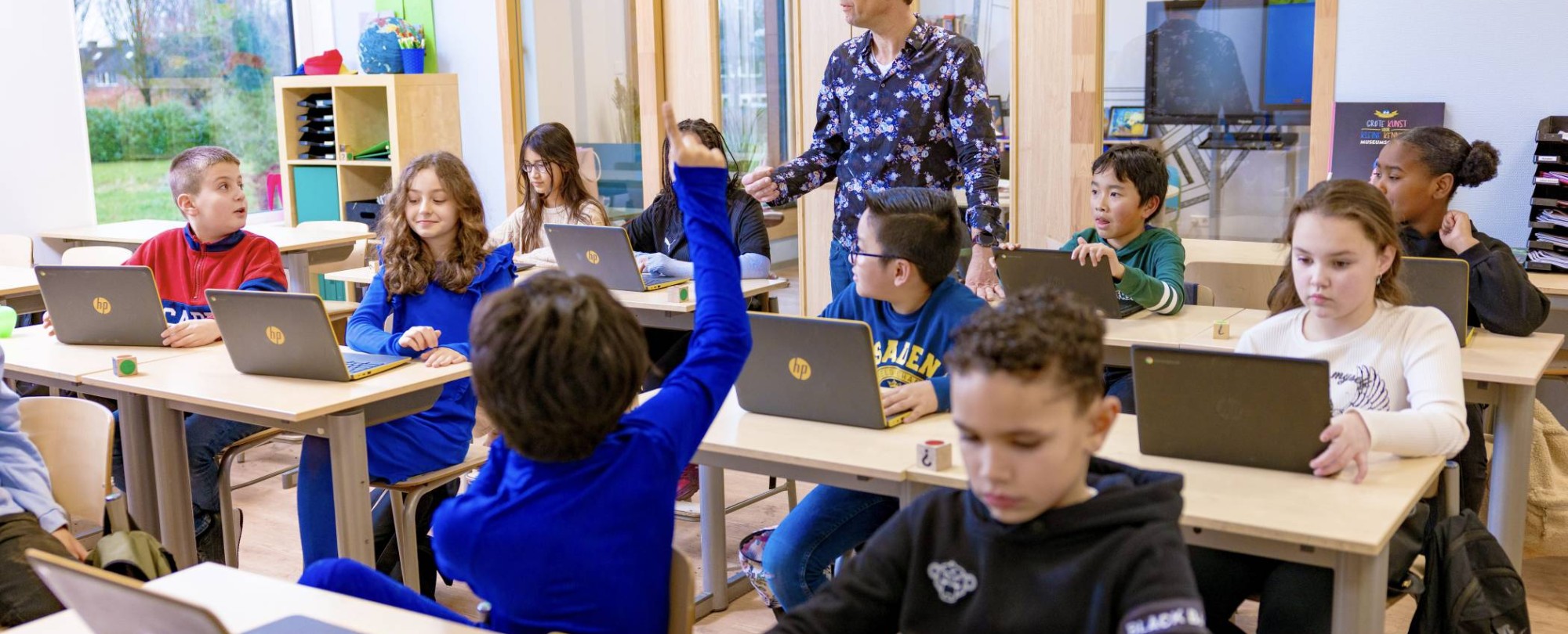 Pabo-docente geeft les aan haar klas en gebruikt daarbij een groot beeldscherm.