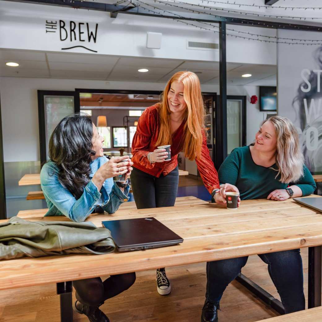Studenten lachen en drinken koffie bij cafe The Brew in Nijmegen
