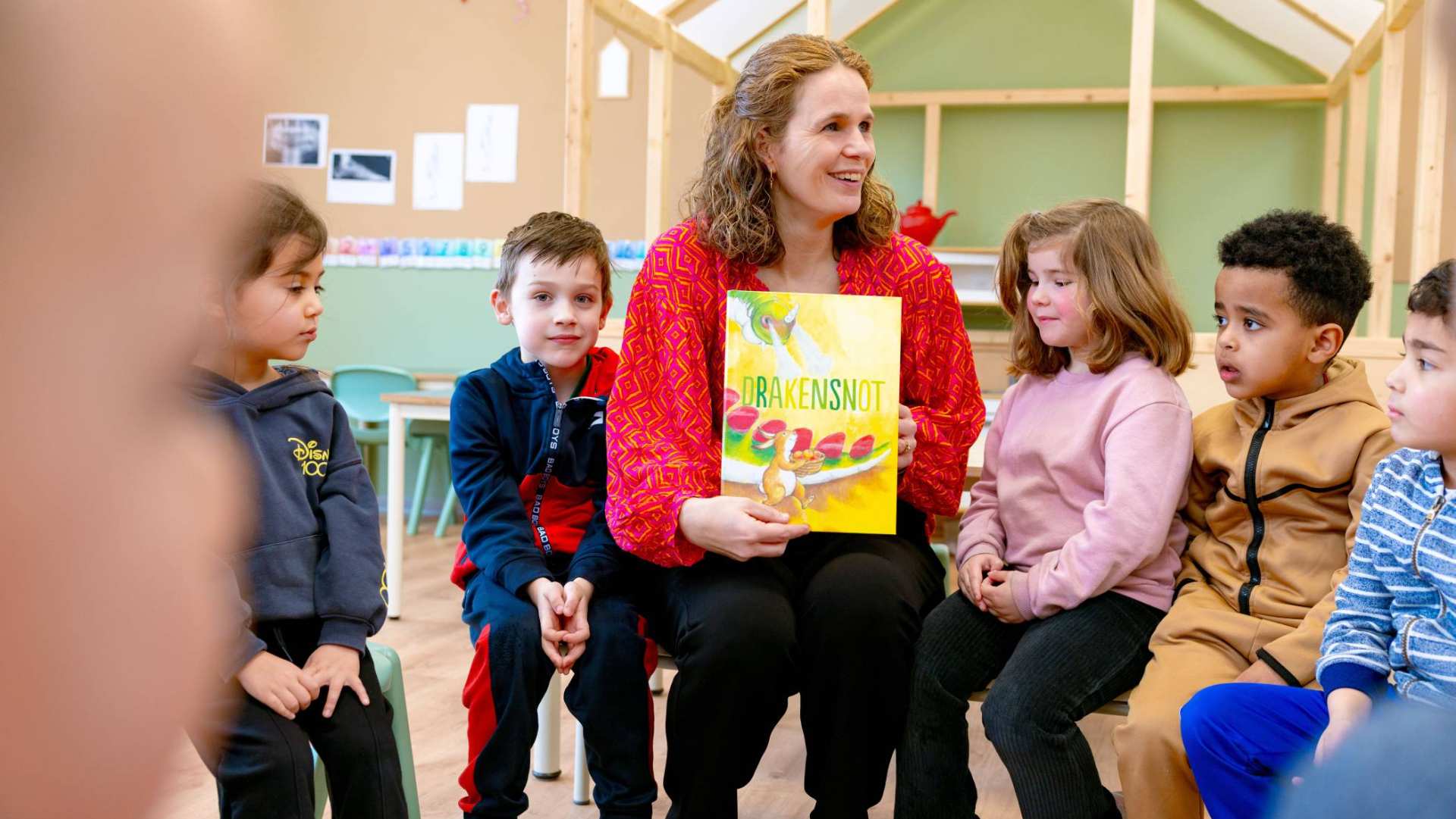 De kleuters op de school De Ommelander. De juf laat het boek drakensnot zien aan de kleuters. 