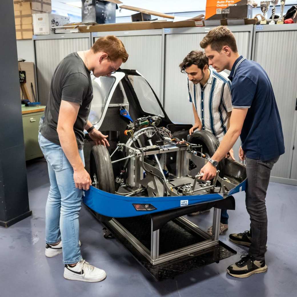 Drie studenten automotive werken samen aan het MH15 voertuig van de HAN.
