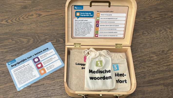 Mirte van Doorn bij de door haar ontwikkelde Taalkoffer, met spellen en tools voor zorgverleners om hen te oefenen met begrijpelijke taal met cliënten te communiceren.