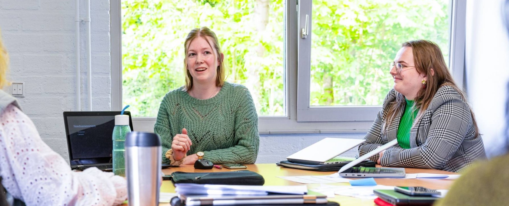 Drie vrouwen die aan het overleggen zijn