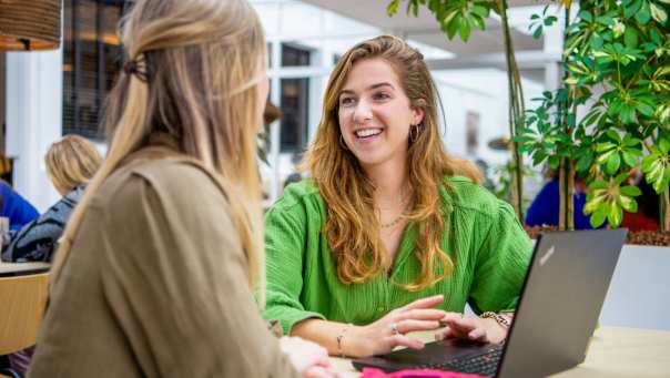 Studenten studeren samen en lachen naar elkaar. 