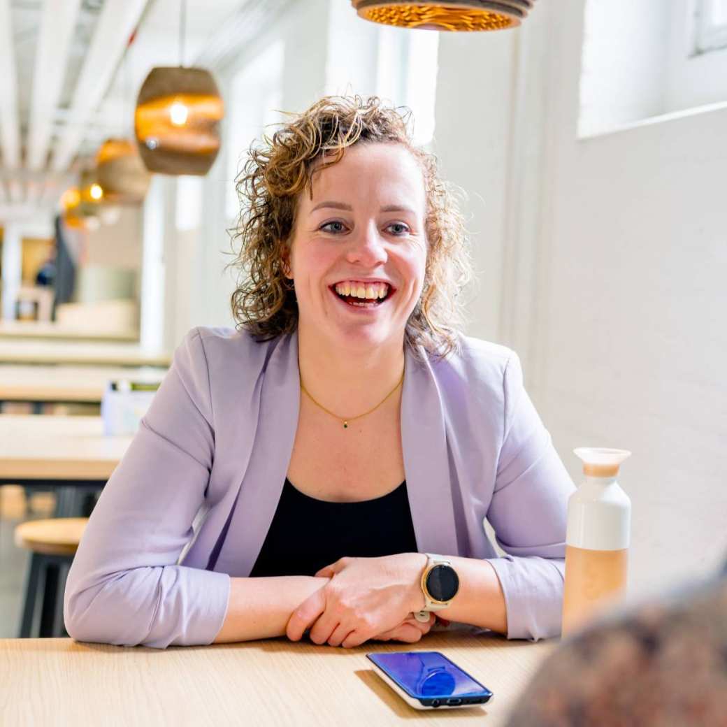 Vrouw in gesprek, moet lachen. Tijdens de cursus acute pijn service, in de kantine.