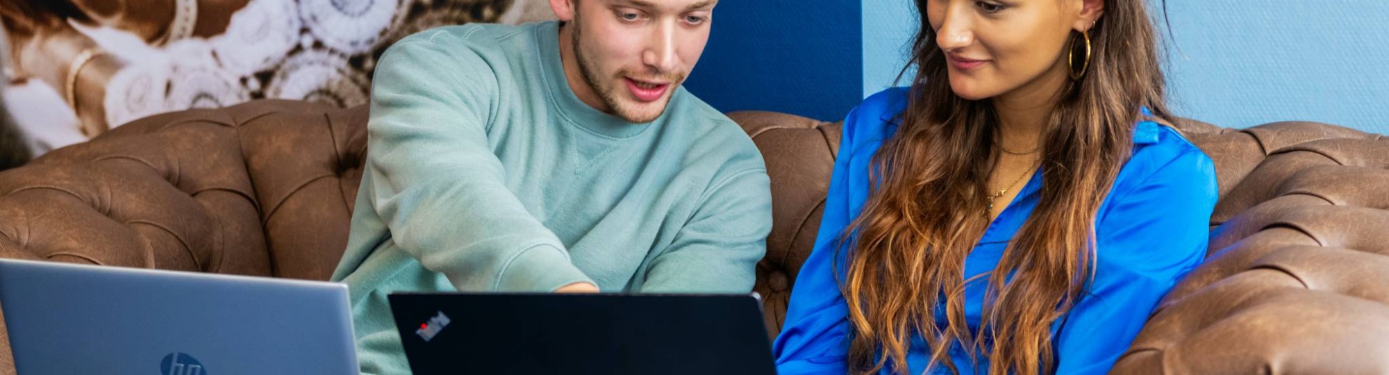 Commerciële Economie 2 studenten op bank met laptop