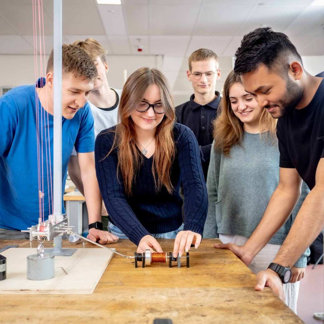 Studenten werktuigbouwkunde doen testen met een katrol en een spoel.