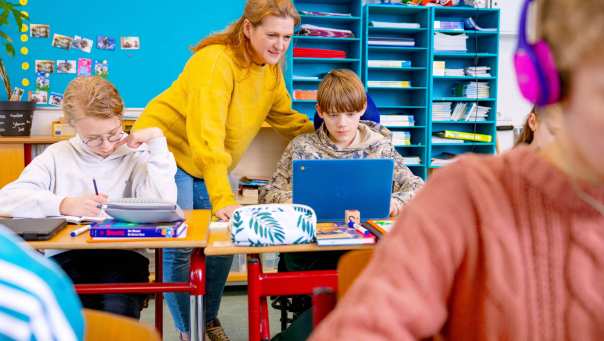 Speciaal Onderwijs op de school Lichtenbeek. De lerares kijkt mee op de laptop van de leerling. 
