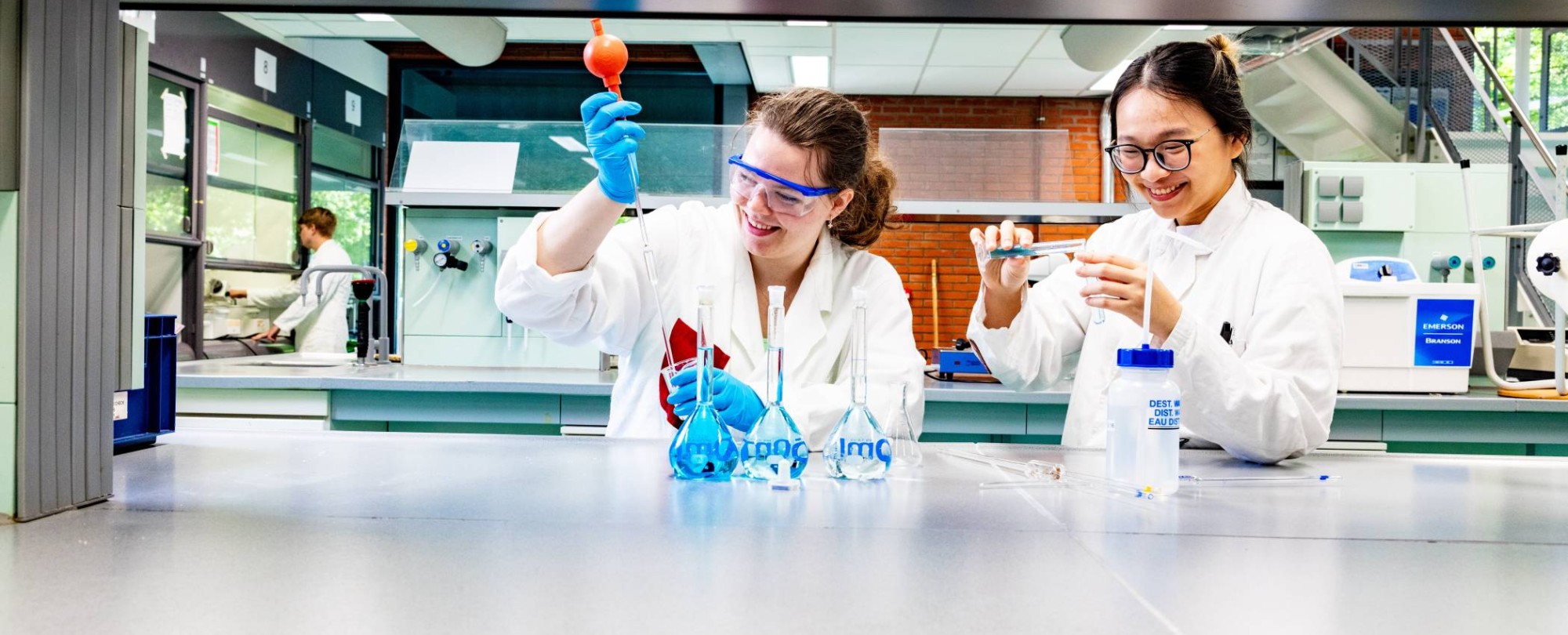 studenten pipetteren in het chemielab