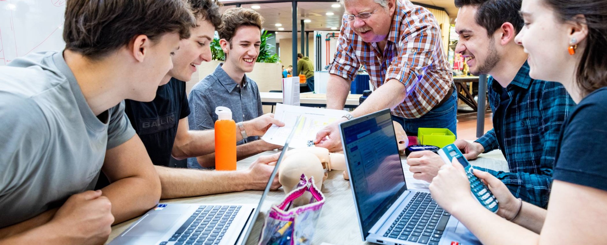 Een docent geeft uitleg aan studenten van de opleiding embedded systems engineering op het health concept lab.