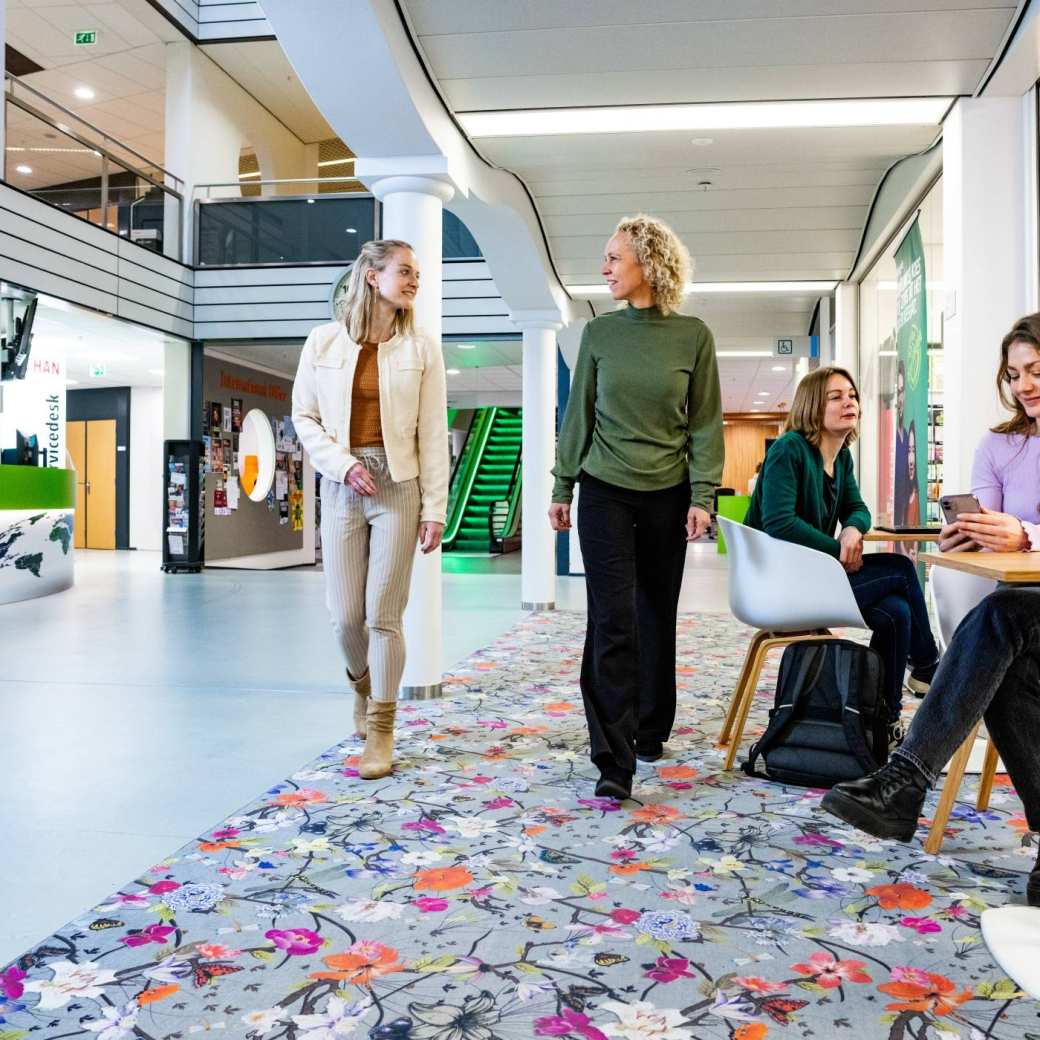 Studenten Bedrijfskunde duaal lopen op de trap op de HAN-campus