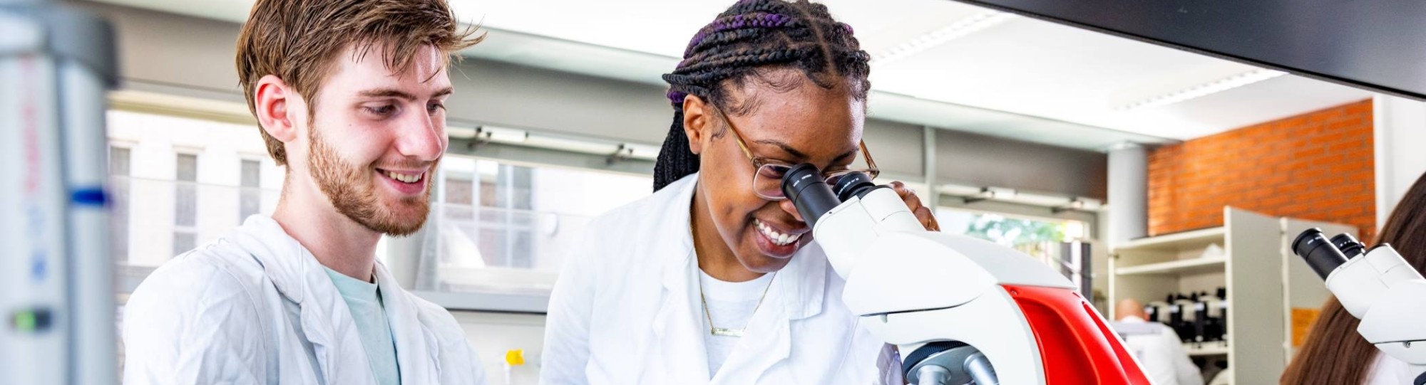 studenten aan het werk met een microscoop