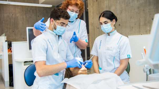 Docent helpt studenten met hoe je een mondzorgkundige behandeling toepast