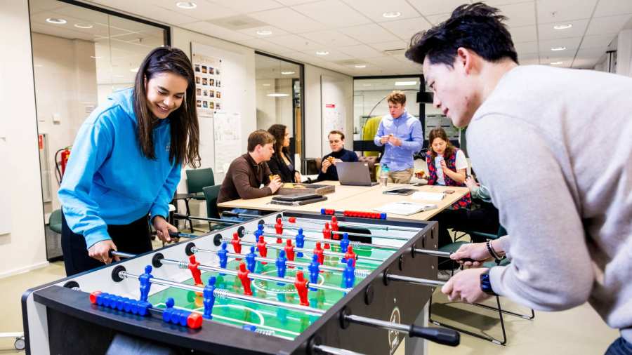 Twee studenten van Bedrijfskunde spelen een potje tafelvoetbal in de studio