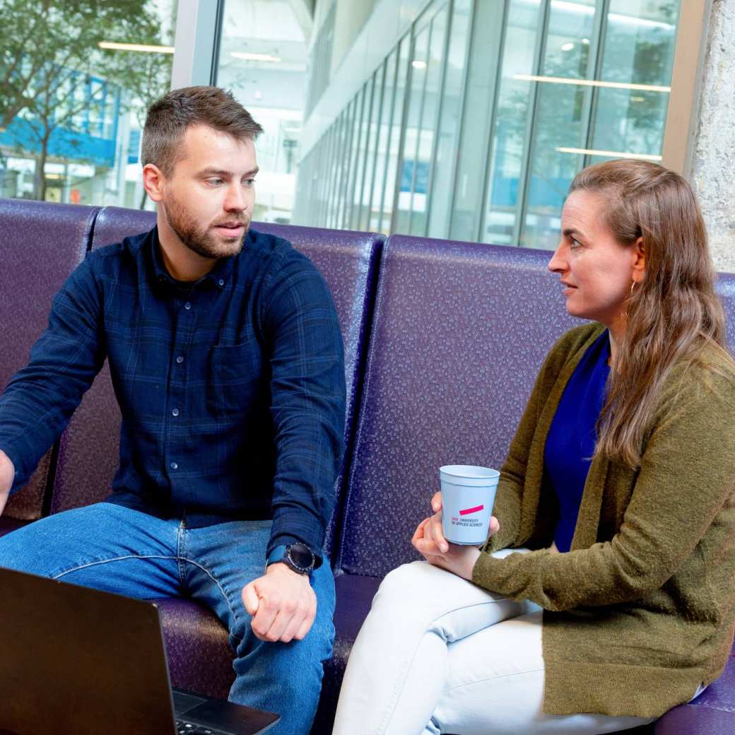 Twee studenten in gesprek met laptop op voorgrond. Master Circulaire Economie (DT) 2024.