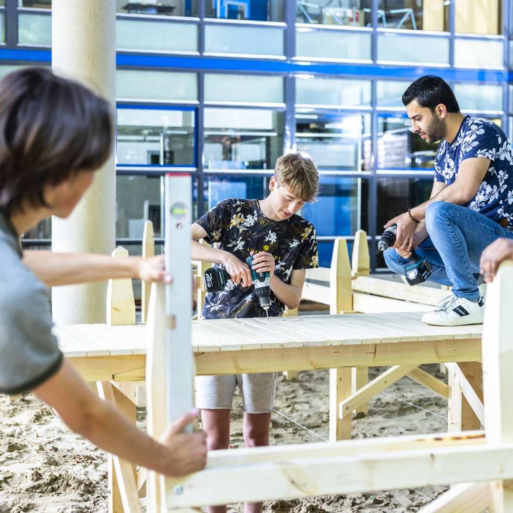 studenten werken aan een steiger onder het gebouw van de opleiding Civiele Techniek