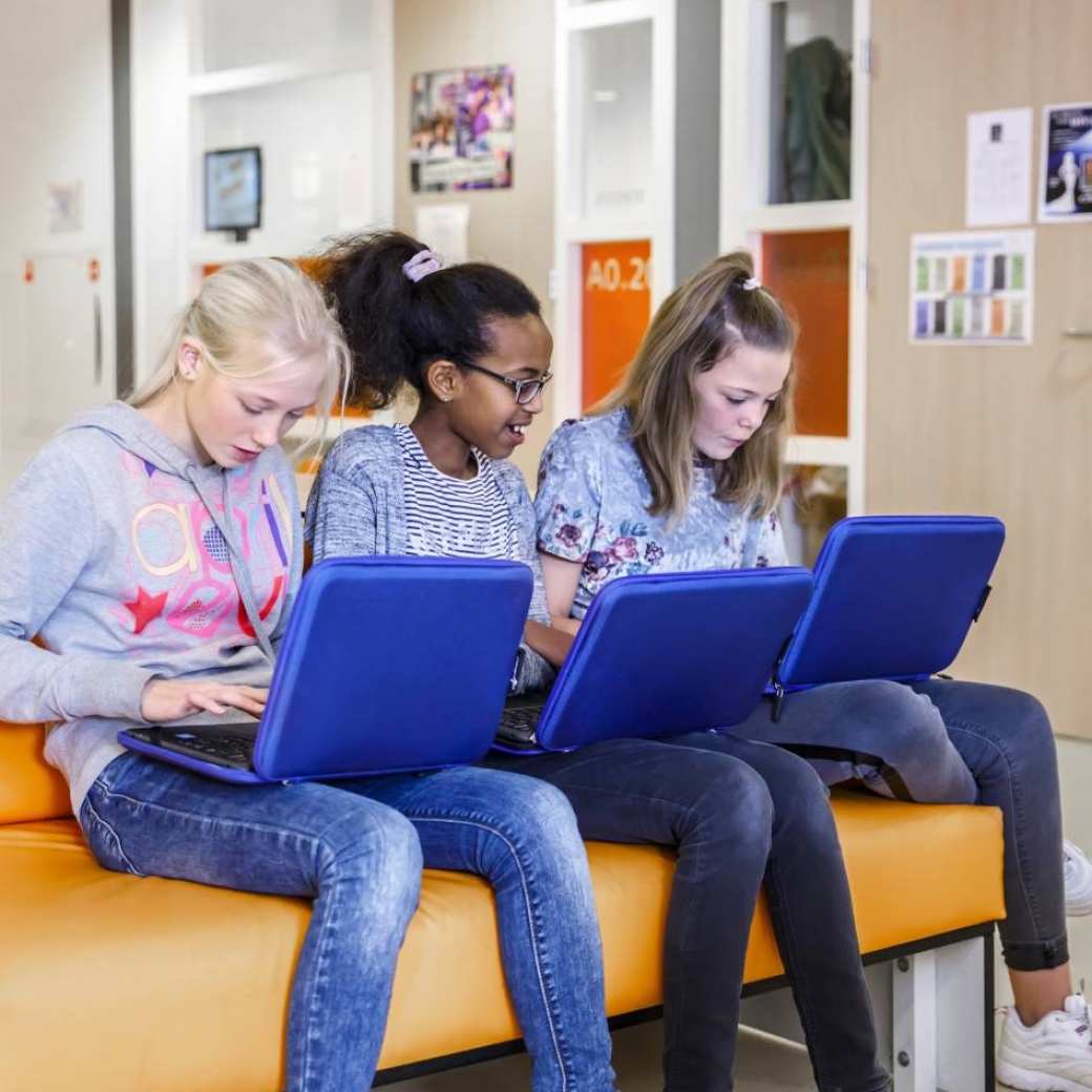 Drie studenten werken op laptop