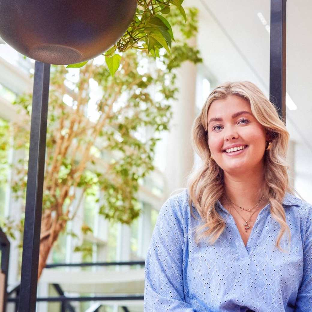 werving voltijd campagne, blonde studente met zachtblauwe blouse kijkt  lachend in de camera.