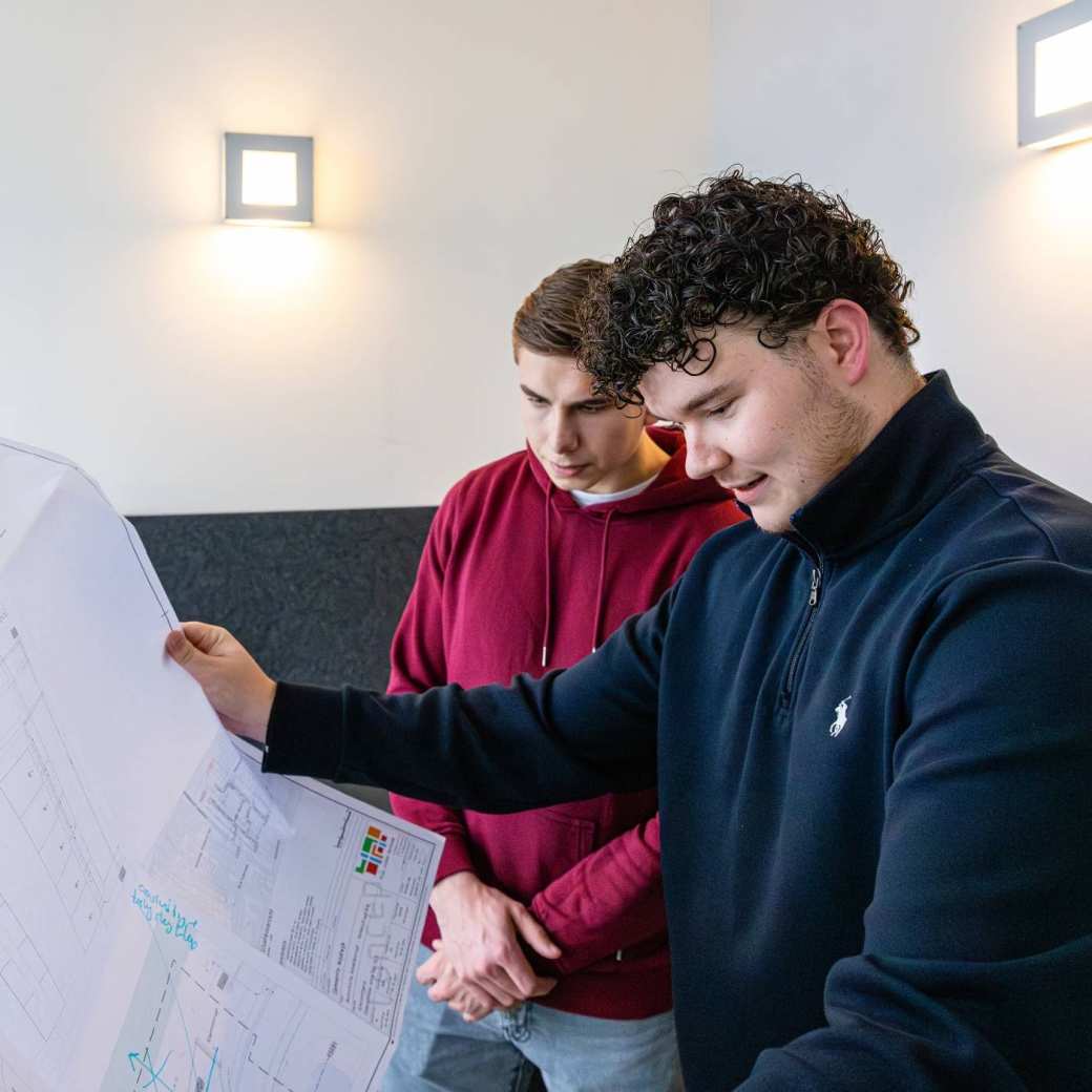 Twee mannen checken samen een grote bouwtekening