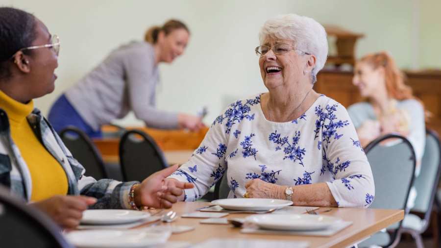 Lachende dame aan eettafel