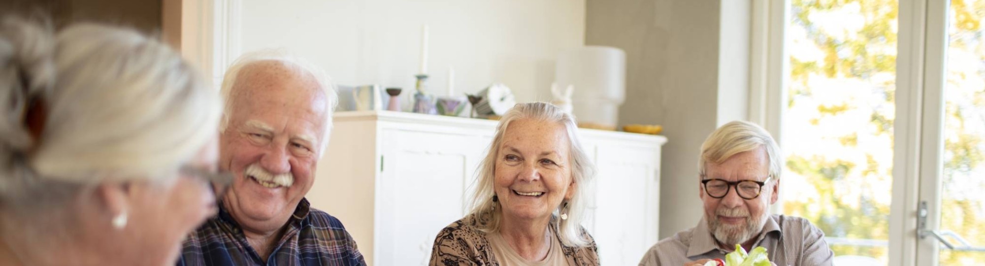 Groep ouderen aan tafel tijdens het ontbijt in een verpleeghuis